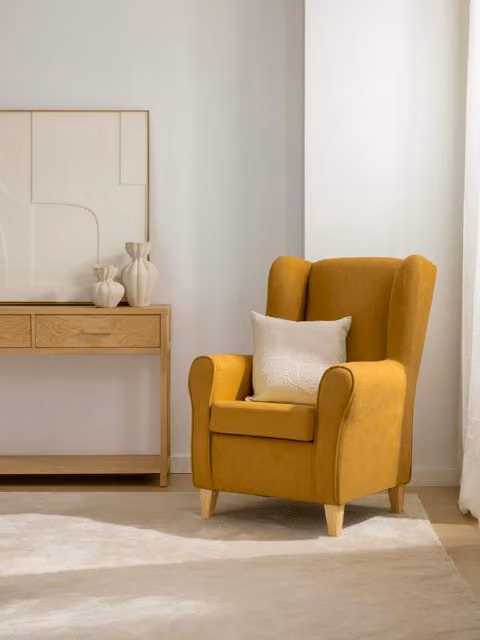 Poltrona imbottita Dan Kenay Home colorazione giallo con struttura in legno e braccioli per il tuo living o camera da letto